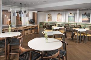 雅典Fairfield Inn & Suites by Marriott Athens的一间带桌椅的餐厅和一间酒吧