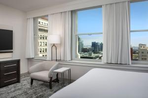圣地亚哥圣地亚哥市区万怡酒店的酒店客房带一张床、椅子和窗户