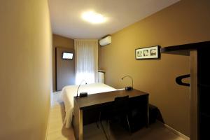 帕多瓦M14 Hotel & Spa的一间卧室配有一张带书桌的床和窗户。