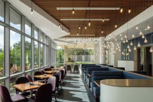 奥兰多The Celeste Hotel, Orlando, a Tribute Portfolio Hotel的餐厅设有桌椅和窗户。