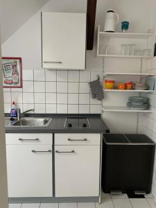 门兴格拉德巴赫Kleines Apartment in Mönchengladbach-Neuwerk的厨房配有白色橱柜和水槽