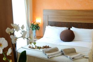 蒙特普齐亚诺伊都耶奇尼酒店的一间卧室配有带毛巾和鲜花的床
