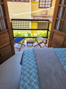 普拉亚多Suíte na vila de Praia do Forte的客房设有带桌椅的阳台。