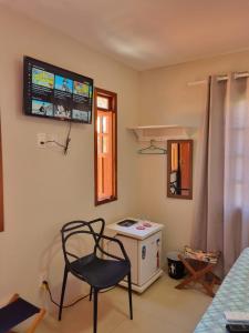 普拉亚多Suíte na vila de Praia do Forte的客房设有椅子、炉灶和窗户。