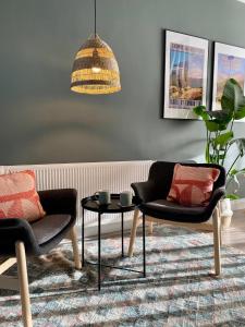 贝尔法斯特The Green Room guest suite的客厅配有两把椅子和一张桌子