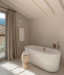 索列尔Can Verí Suites的白色的浴室设有浴缸和窗户。
