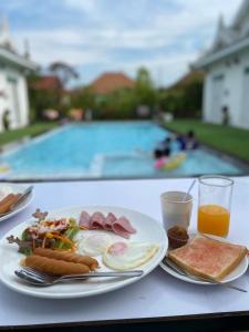 七岩Bianco House Resort的一张桌子,上面有一盘早餐食品和一个游泳池