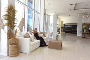 拉马约Camberland Resort & Spa Ramallo的坐在客厅沙发上的女人
