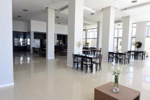 拉马约Camberland Resort & Spa Ramallo的用餐室设有桌椅和窗户。