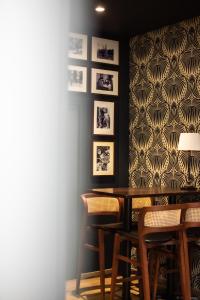 贝叶Churchill Hotel Bayeux Centre的用餐室配有桌椅和图片墙