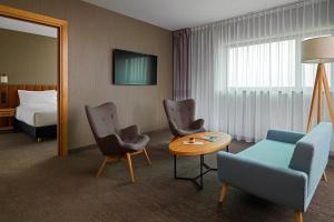 华沙Four Points by Sheraton Warsaw Mokotow的酒店客房带一张床、一张桌子和椅子