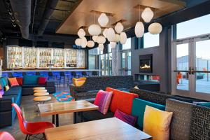 韦科Aloft Waco Downtown的餐厅配有色彩缤纷的家具和桌子