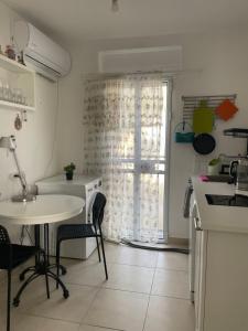 兹奇隆亚科夫my holiday apartment的厨房配有桌子、水槽和窗户