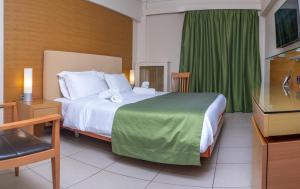 马尔马里马尔马里湾酒店的一间卧室配有一张带绿帘的大床