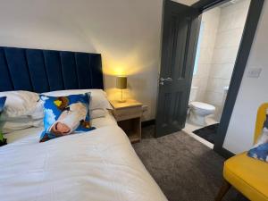 TubberThe Burren Inn的一间卧室配有一张带蓝色床头板的床和卫生间