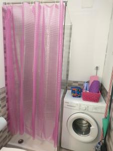 巴哈马尔Estudio La Luna的浴室内洗衣机上方的粉红色淋浴帘