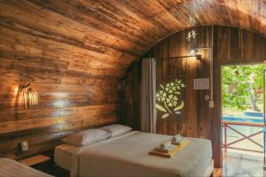 富国Phu Quoc Valley Sen Bungalow的卧室配有木墙内的一张床