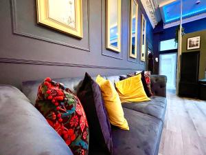 利物浦AdeamStays provides Beautiful centrally located 1 and 2 bed apartments on Liverpools Boulevard的客厅配有带黄色枕头的灰色沙发