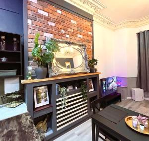 利物浦AdeamStays provides Beautiful centrally located 1 and 2 bed apartments on Liverpools Boulevard的一间客厅,在砖墙上设有镜子