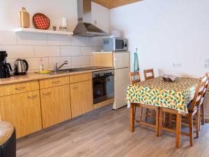 卢布明Bungalow Neues Atelier的厨房配有桌子和炉灶。 顶部烤箱