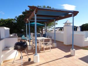 Praia VerdeFarol da Cortesia - Praia Verde的屋顶凉亭,配有桌椅