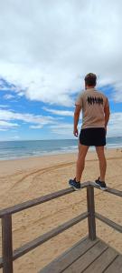 阿尔坎塔里利亚Villa Algarve的站在海滩围栏上的男人