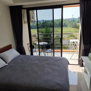 迈考海滩777 Beach Condo Phuket的一间卧室设有一张床,享有阳台的景色