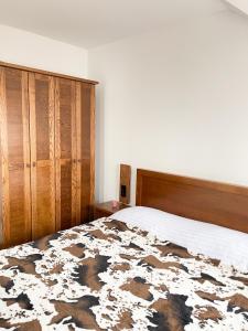 普拉夫Apartments & Rooms Brijest的一间卧室配有一张大床和一个木制橱柜
