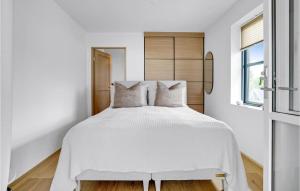凯特明讷Awesome Apartment In Kerteminde With House Sea View的卧室配有白色的床和木制床头板