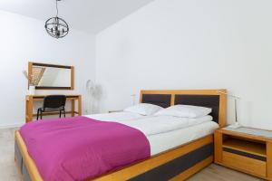 达尔沃沃DreamHouse Apartament „Laguna” ul. Wschodnia 12, Darłówko Wschodnie的一间卧室配有一张大床和紫色毯子