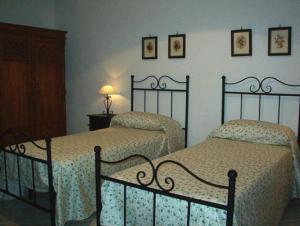 焦约萨马雷阿Residence L'uliveto的卧室设有两张单人床和两盏灯。