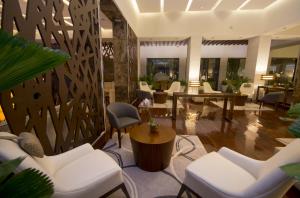 波拉马尔SUNSOL UNIK Luxury Hotel的大堂设有白色的椅子和桌子