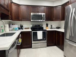 基奇纳Hestia Unit的厨房配有木制橱柜和不锈钢用具