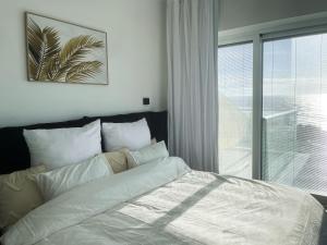 哈德拉Sea Resort的卧室配有白色的床和窗户