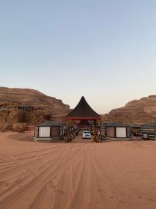 瓦迪拉姆Wadi Rum Khalid luxury camp的沙漠中的一个凉亭下停下的汽车