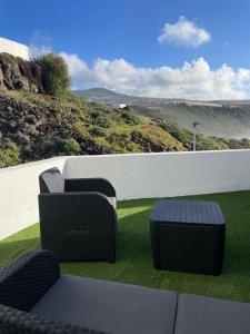 拉拉古纳Sunset Dream, casa en la playa con terraza的景观阳台配有2把椅子和桌子