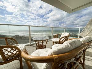 哈德拉Sea Resort的阳台配有椅子、沙发和桌子