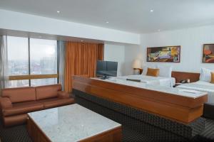 墨西哥城塞维利亚宫的酒店客房配有床、沙发和电视。