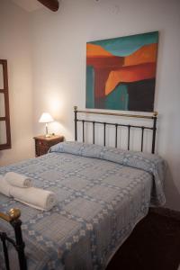 卡奇Tampu的卧室内的一张床铺,墙上有绘画作品