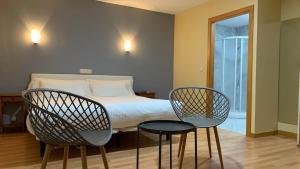 锡古恩萨Hotel Posta Real的一间卧室配有两把椅子、一张床和窗户