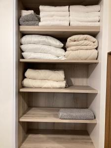 兹奇隆亚科夫Midrahov Luxury Apartment的衣柜里装满了白色的毛巾