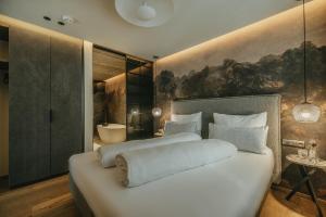迈尔霍芬Black Eagle Luxury Appartements的一间带白色大床的卧室和一间浴室