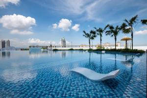 大山脚Metropol Serviced Apartment - Bukit Mertajam的水中带白色椅子的游泳池