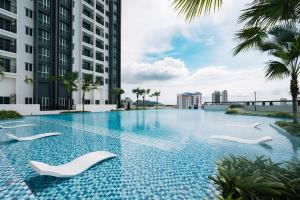 大山脚Metropol Serviced Apartment - Bukit Mertajam的一座大楼中央的带白色椅子的游泳池