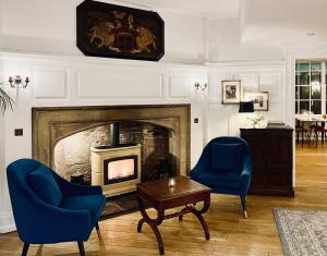 沃里克沃里克武器旅馆的客厅设有壁炉和2把蓝色椅子