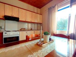 费斯卡尔德宏Affordable vintage apartment near Fiscardo & Assos的厨房配有桌子、炉灶和窗户。
