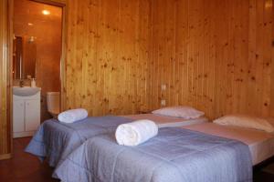 VilarrodonaRocaplana Club de Campo的木镶板客房内的两张床