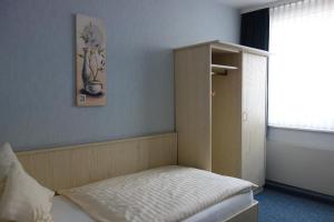 哈根莱克斯酒店的客房设有一张带橱柜和窗户的床。
