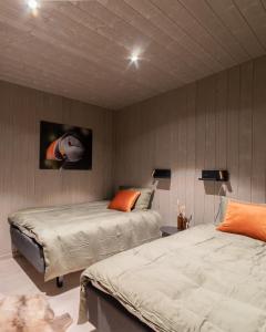 瓦尔德Varanger View的一间卧室设有两张床,墙上挂有鱼画