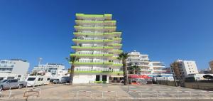 蒙蒂戈杜Monte Gordo T2 Frente Mar的停车场内棕榈树的高楼公寓
